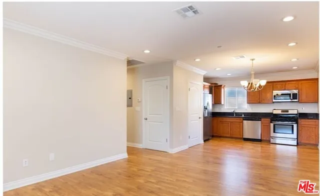a kitchen with stainless steel appliances granite countertop a refrigerator and a stove top oven