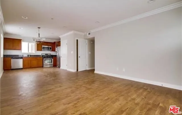 a view of a kitchen with furniture and wooden floor
