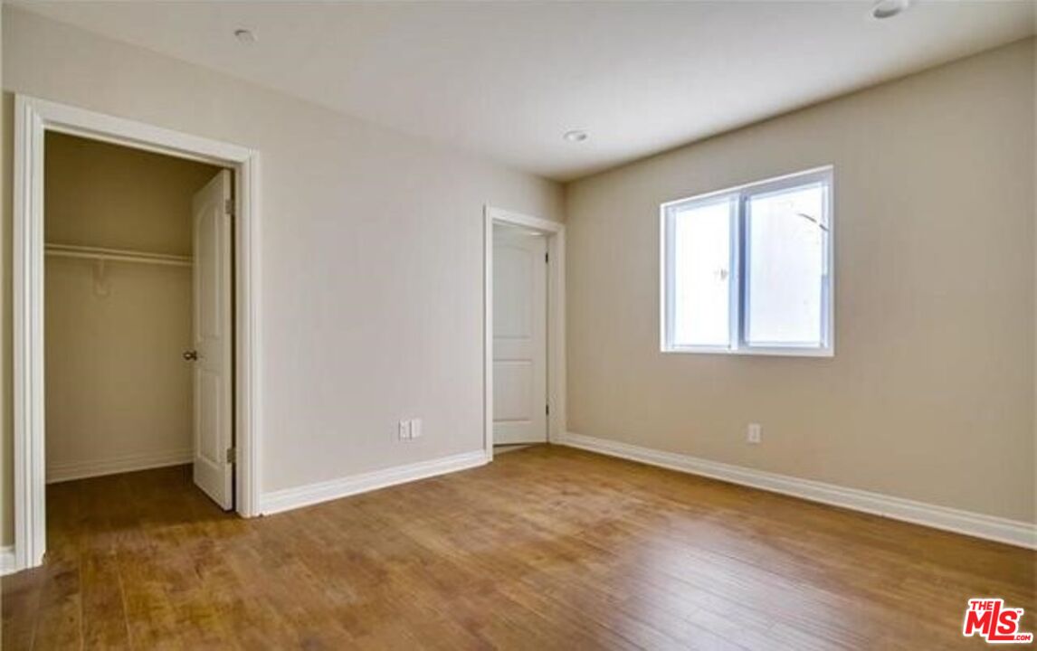 1203 1/2 South Catalina Street Los Angeles, CA 90006 - Photo 9 of 11 a view of an empty room with wooden floor and a window