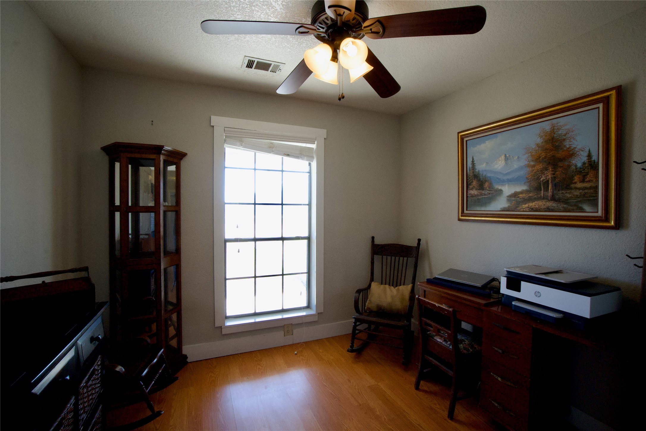 2352 Borchert Loop Lockhart, TX 78644 - Photo 20 of 39 a view of workspace with wooden floor windows cabinet and a ceiling fan