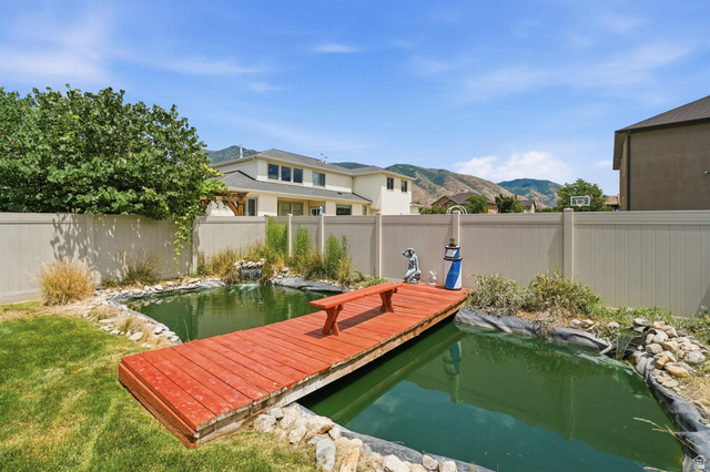 592 West 650 South Springville, UT 84663 - Photo 23 of 33 Backyard water feature with a red wooden dock and integrated seating for Koi pond