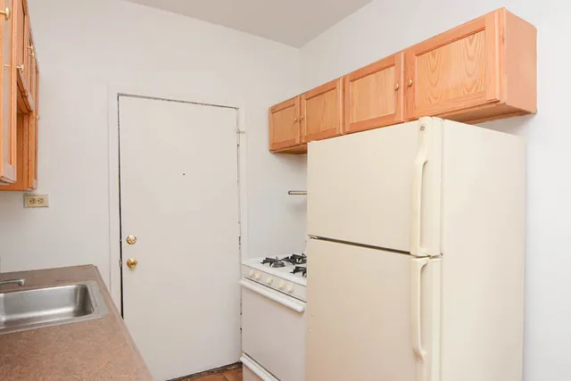 a white refrigerator freezer and a stove sitting inside of a kitchen