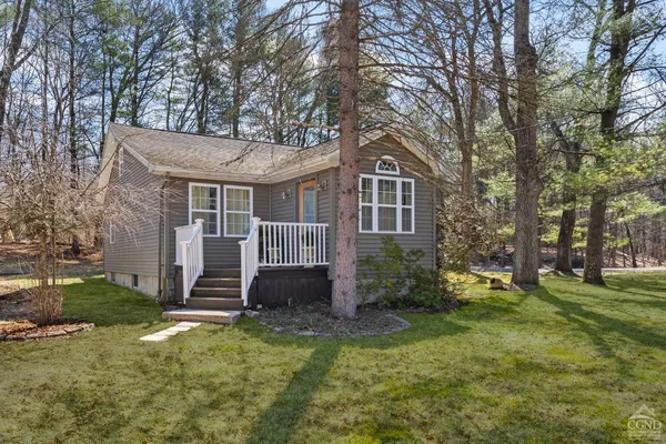 a view of a house with backyard and tree