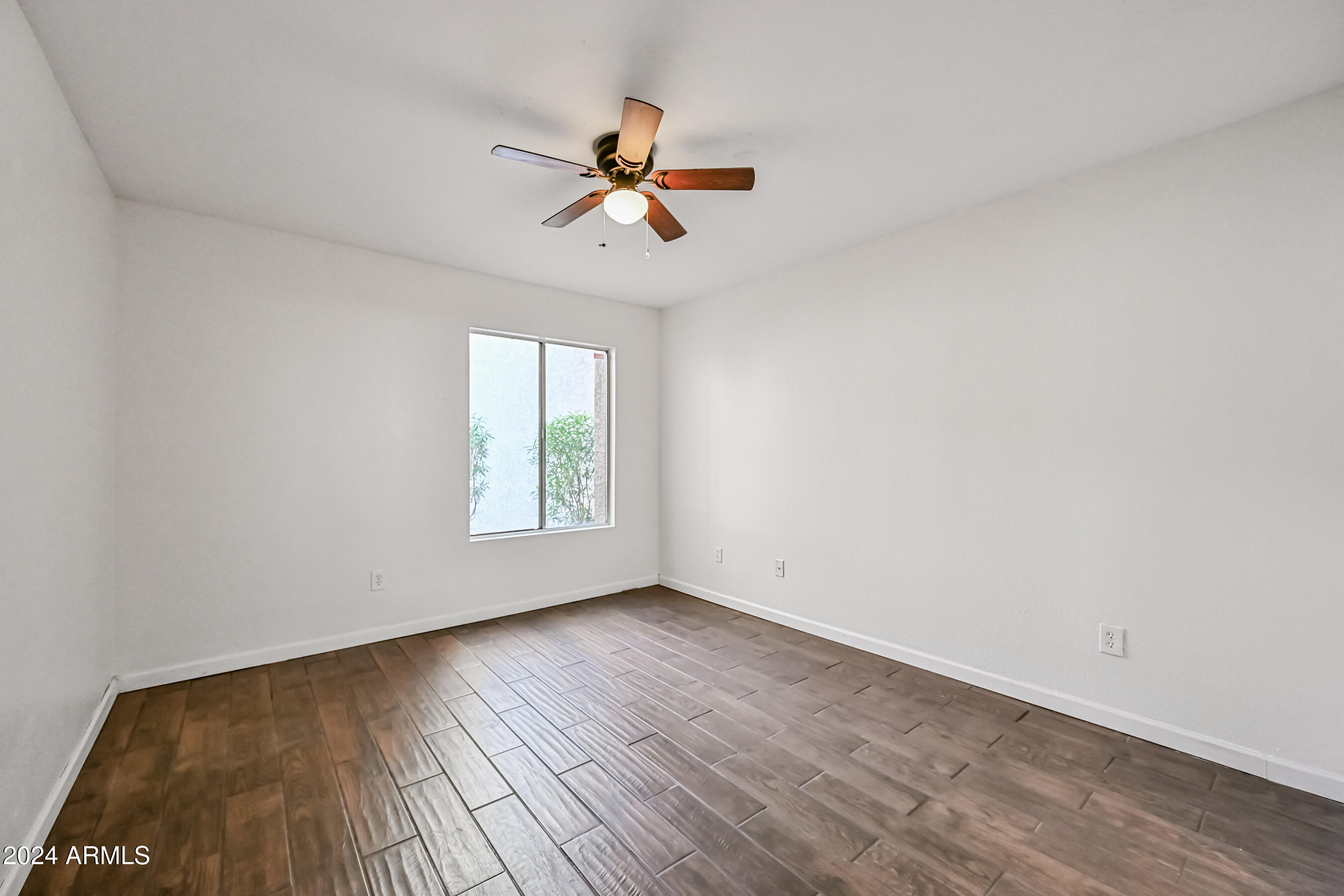 10610 South 48th Street, Unit 1081 Phoenix, AZ 85044 - Photo 14 of 17 a view of empty room with wooden floor and fan