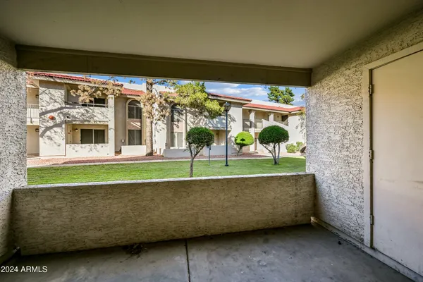 a view of a house with a big yard potted plants and large tree