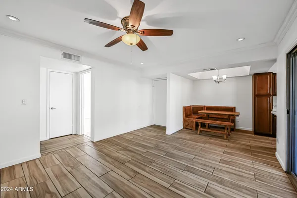 a view of empty room with wooden floor and fan