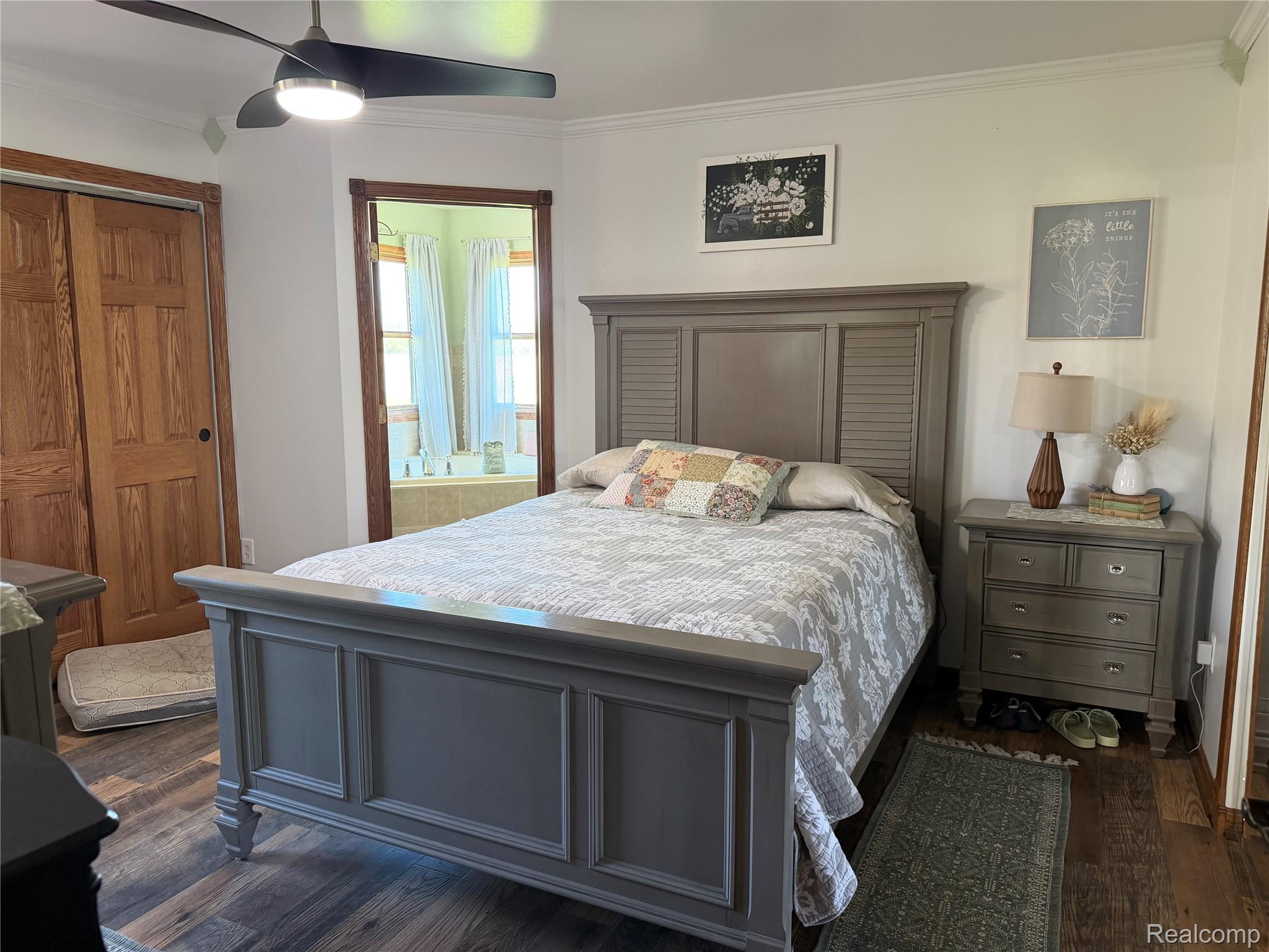 6860 Grand River Road Bancroft, MI 48414 - Photo 12 of 31 Bedroom featuring ornamental molding, a closet, ceiling fan, and dark wood-type flooring