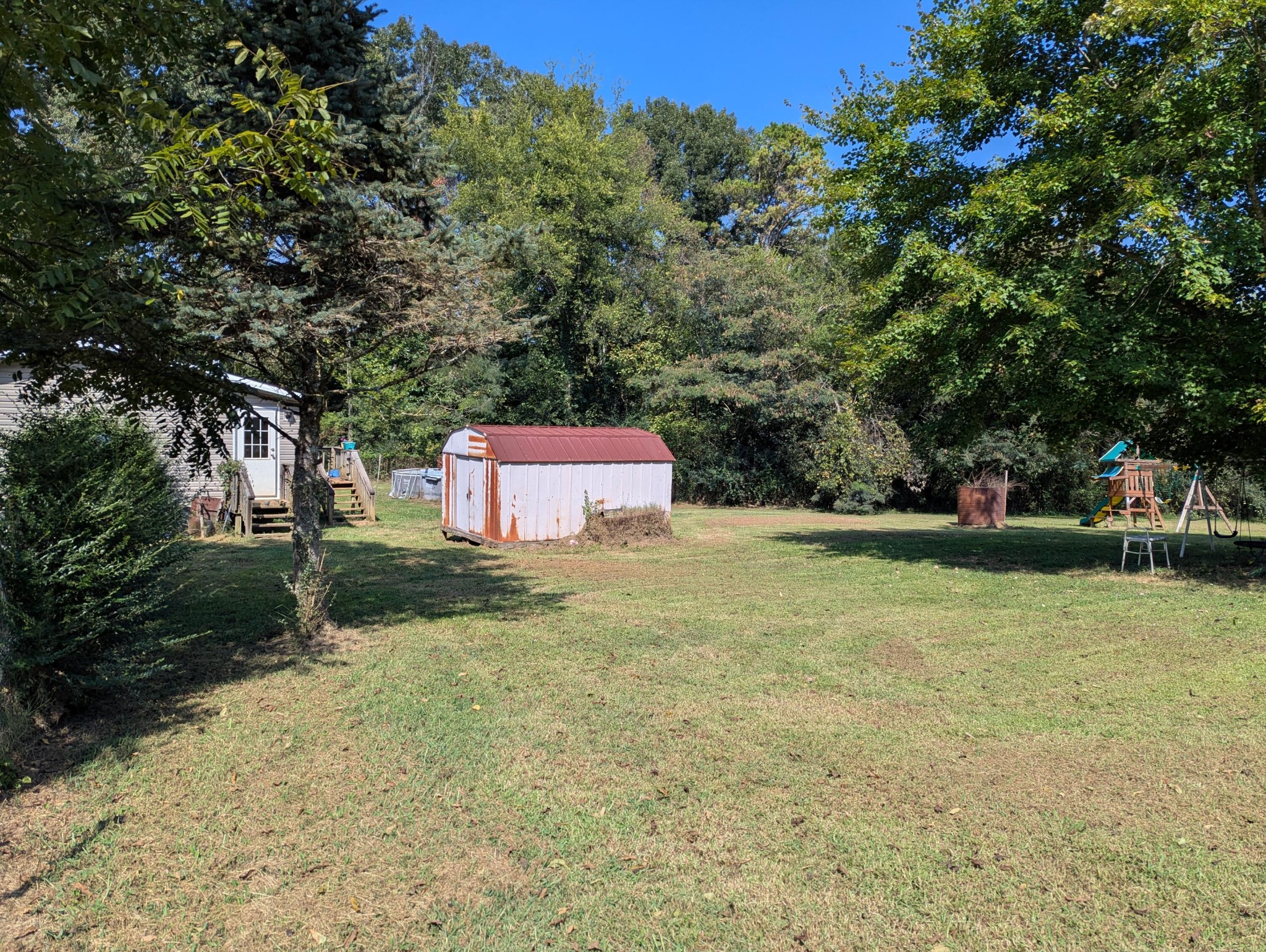 313 Burton Road Sweetwater, TN 37874 - Photo 37 of 38 a backyard of a house with trees and outdoor seating
