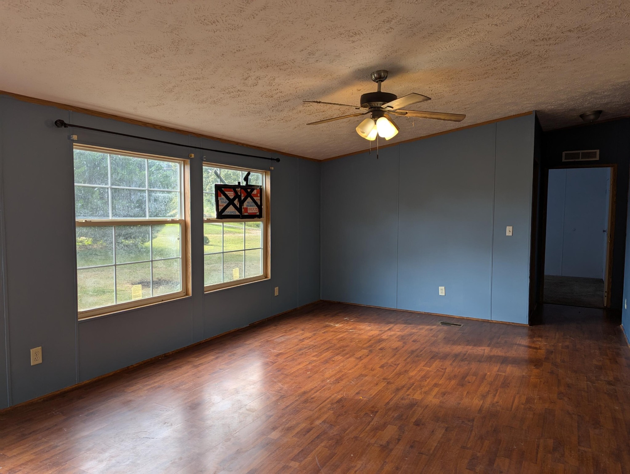 313 Burton Road Sweetwater, TN 37874 - Photo 4 of 38 an empty room with wooden floor chandelier fan and windows