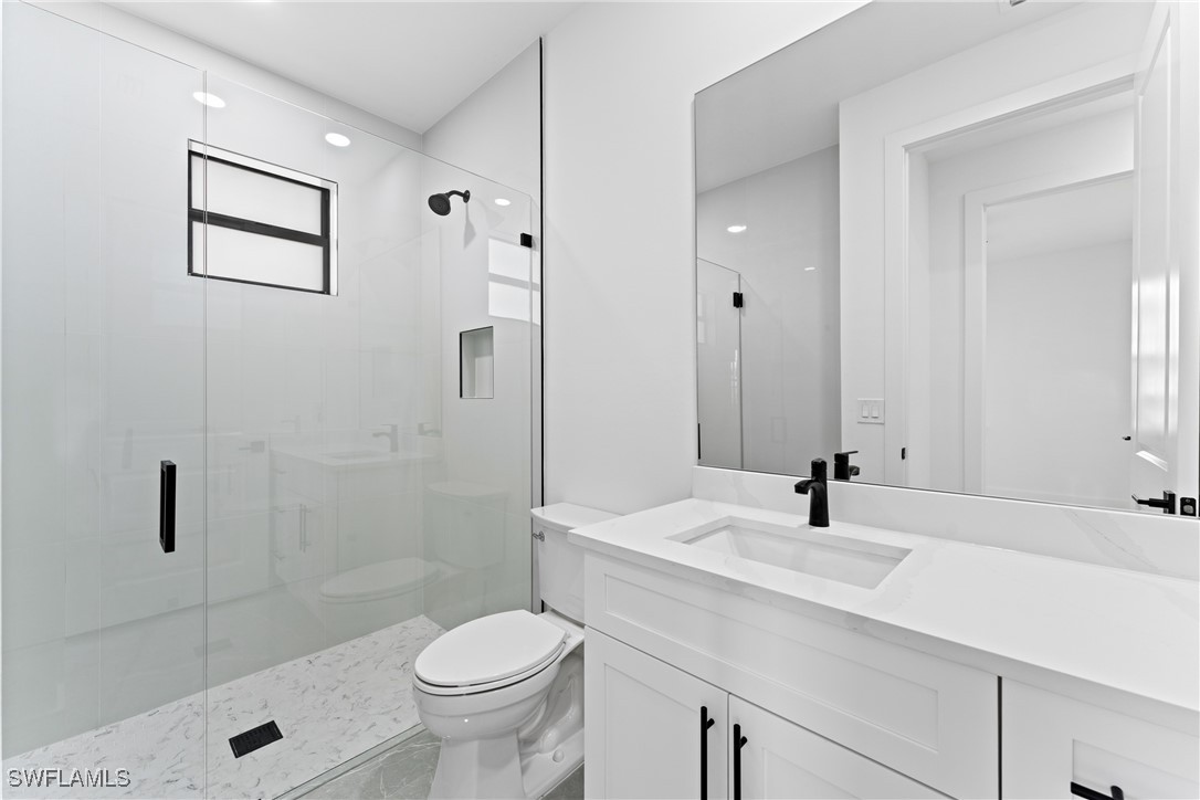 1024 Chauncey Avenue Lehigh Acres, FL 33971 - Photo 17 of 39 a bathroom with a sink a toilet and shower