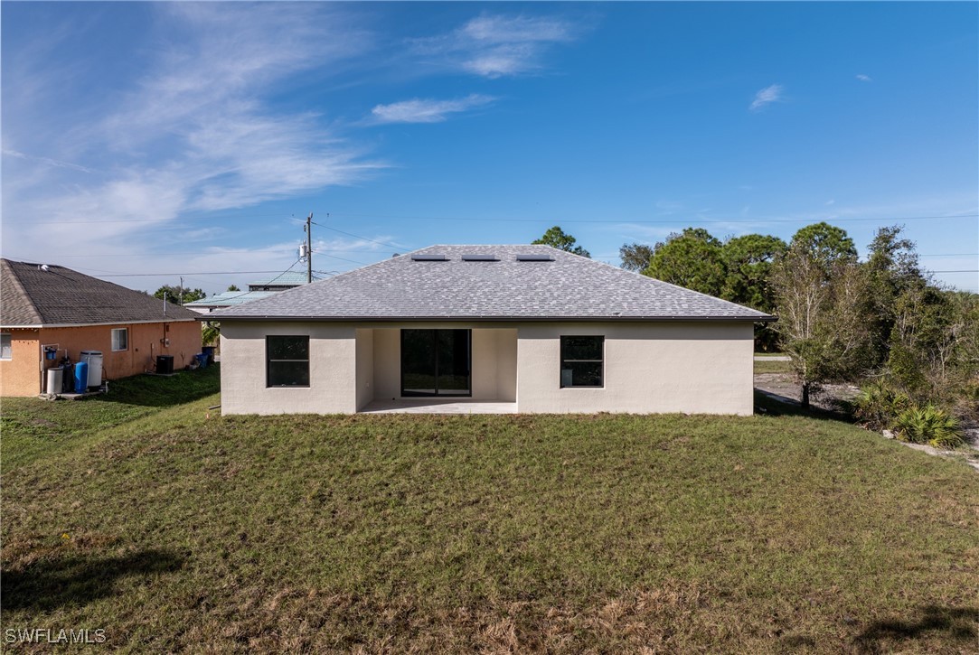 1024 Chauncey Avenue Lehigh Acres, FL 33971 - Photo 33 of 39 a front view of a house with a yard