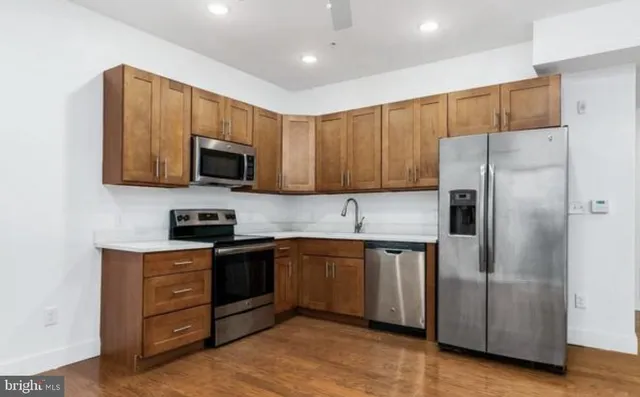 a kitchen with stainless steel appliances granite countertop a refrigerator and a stove top oven