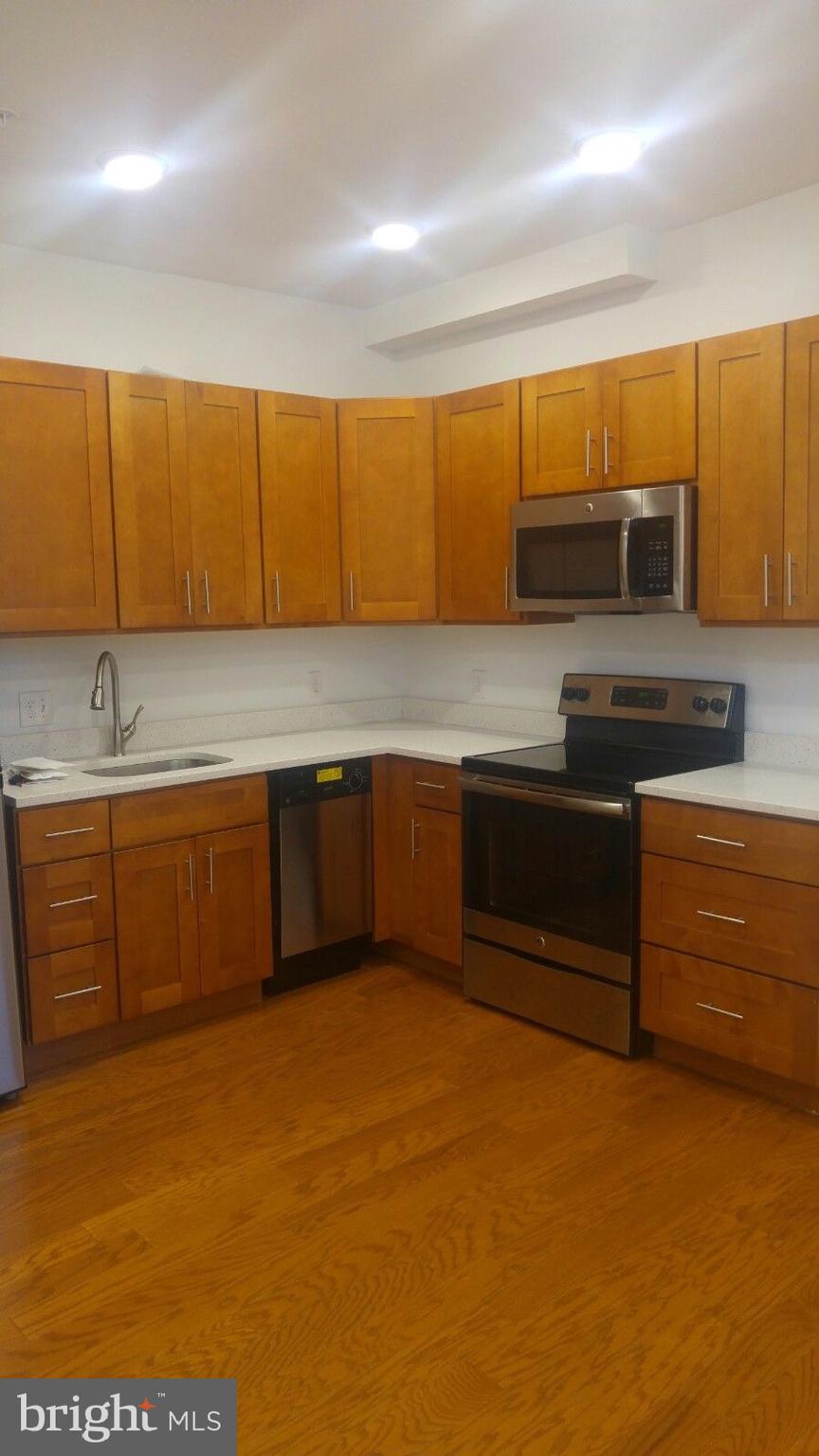 1637-39 Poplar Street, Unit LL1 Philadelphia, PA 19130 - Photo 8 of 13 a kitchen with stainless steel appliances granite countertop a sink and cabinets