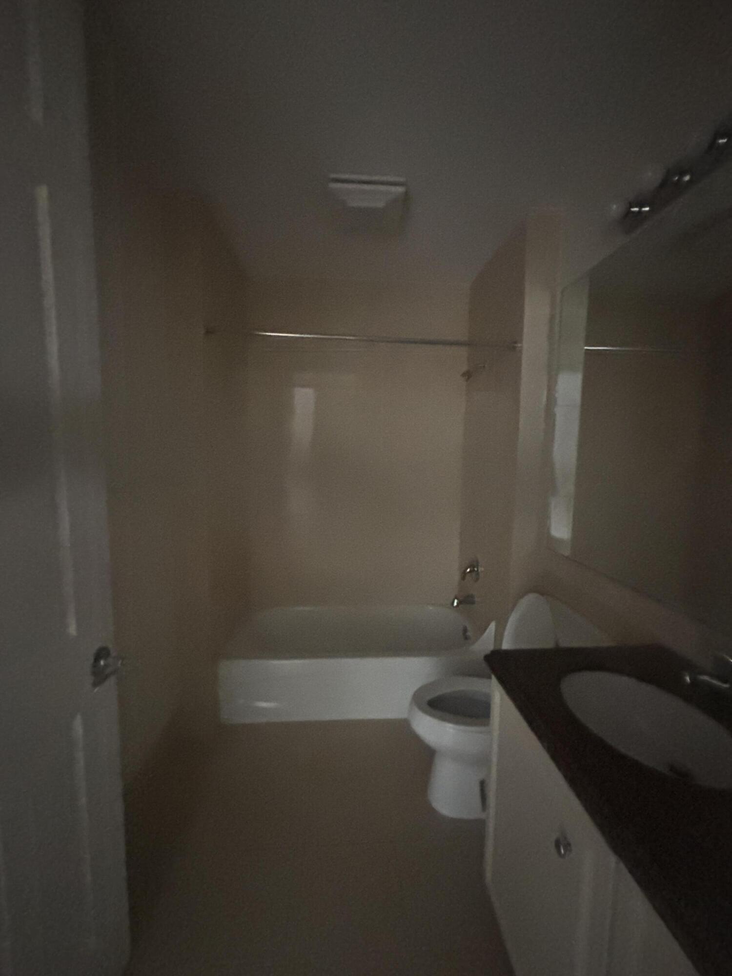 17 Harbour Isle Drive West, Unit 103 Fort Pierce, FL 34949 - Photo 10 of 17 a bathroom with a granite countertop sink a toilet and shower