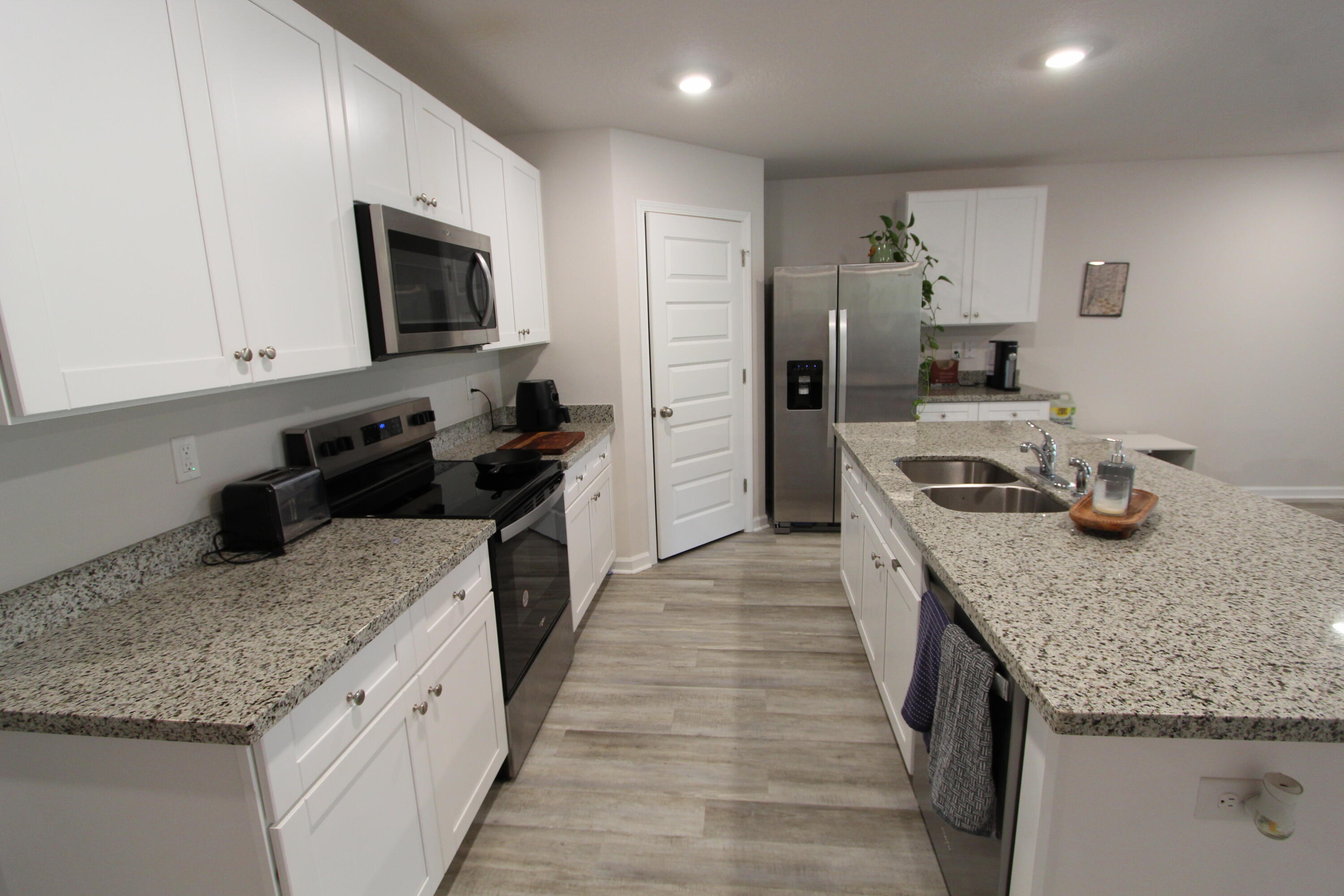 3063 Jane Lane Crestview, FL 32539 - Photo 17 of 30 a kitchen with stainless steel appliances granite countertop a sink stove and refrigerator