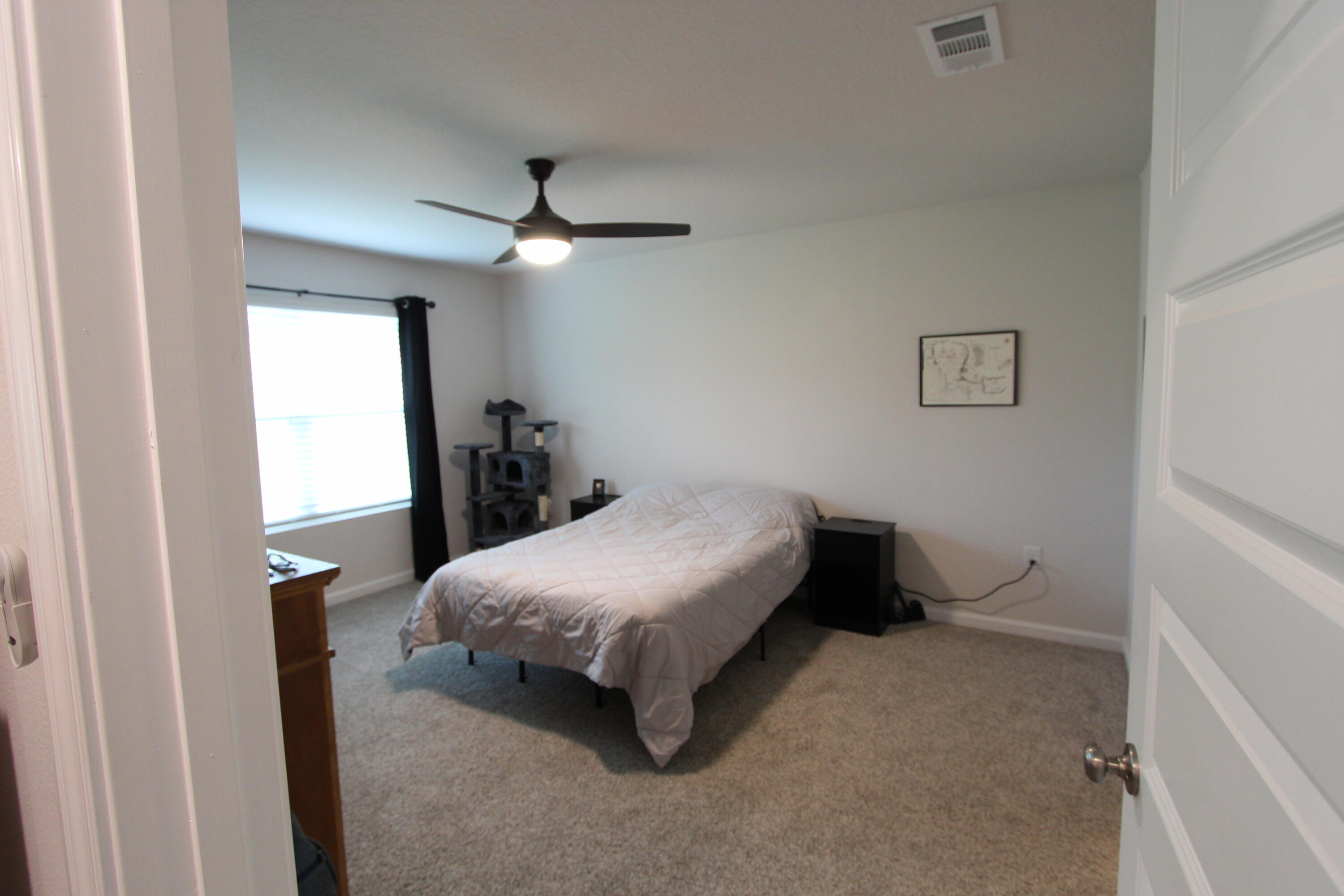 3063 Jane Lane Crestview, FL 32539 - Photo 24 of 30 a bedroom with a bed and a chandelier