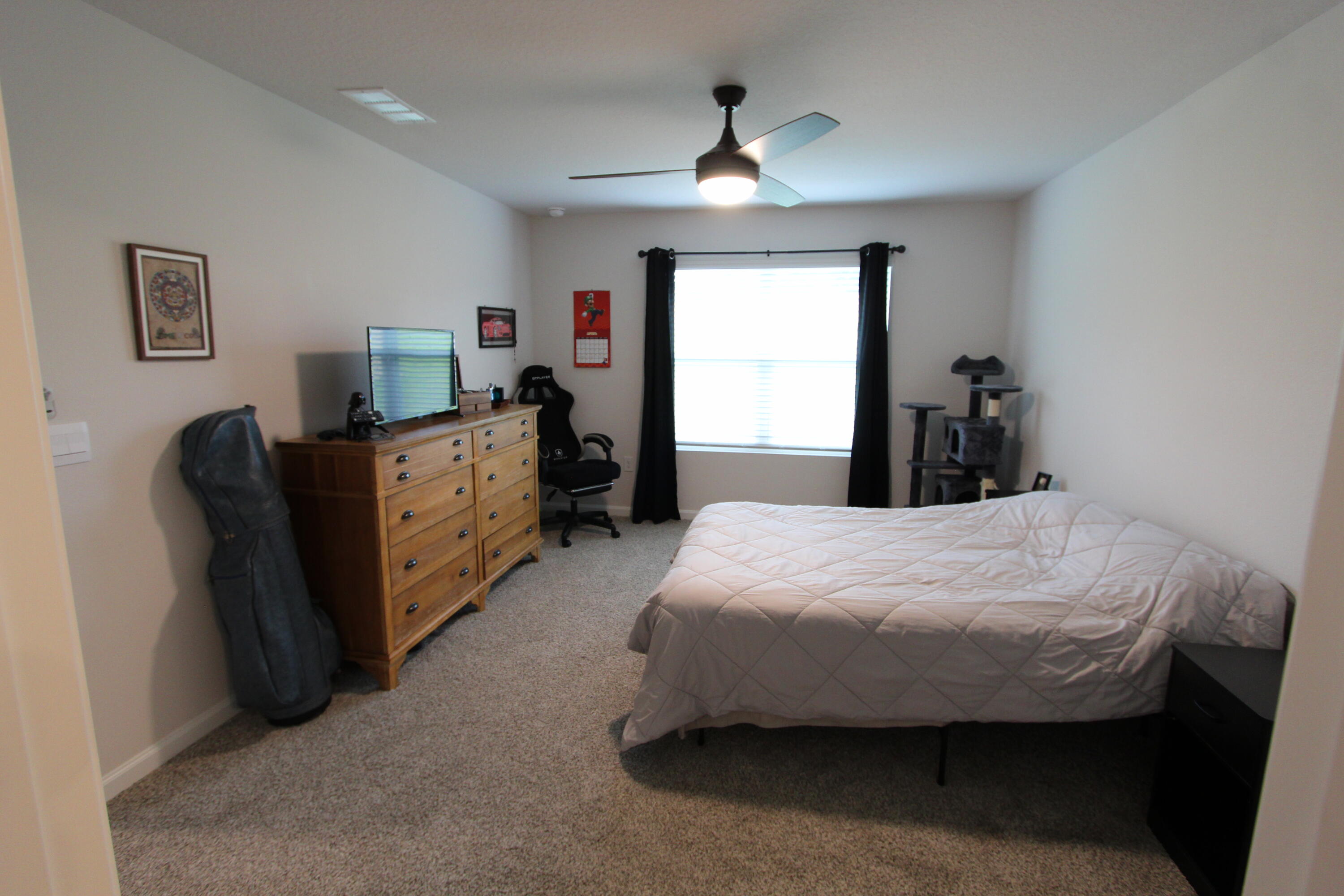 3063 Jane Lane Crestview, FL 32539 - Photo 25 of 30 a bedroom with a bed and a chandelier