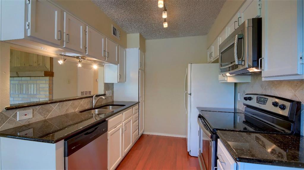 908 Poplar Street, Unit 203 Austin, TX 78705 - Photo 2 of 9 a kitchen with granite countertop a stove and a sink