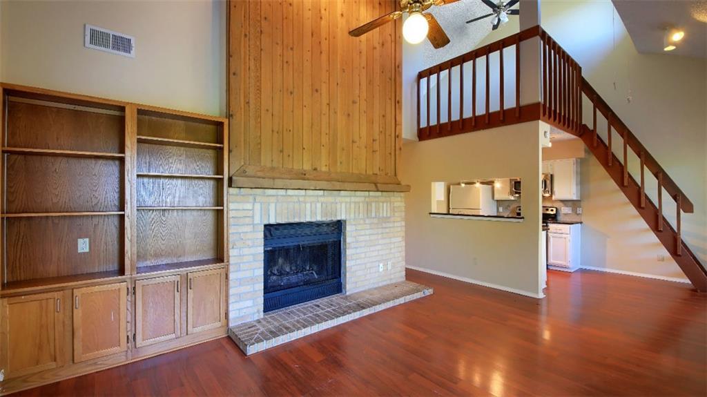 908 Poplar Street, Unit 203 Austin, TX 78705 - Photo 6 of 9 a view of an empty room with wooden floor and a fireplace