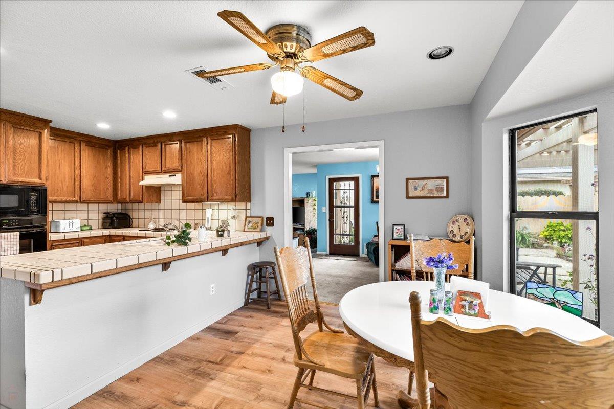 2136 Candy Cane Walk Manteca, CA 95336 - Photo 18 of 60 a kitchen with stainless steel appliances granite countertop a stove a refrigerator a kitchen island with a dining table and chairs