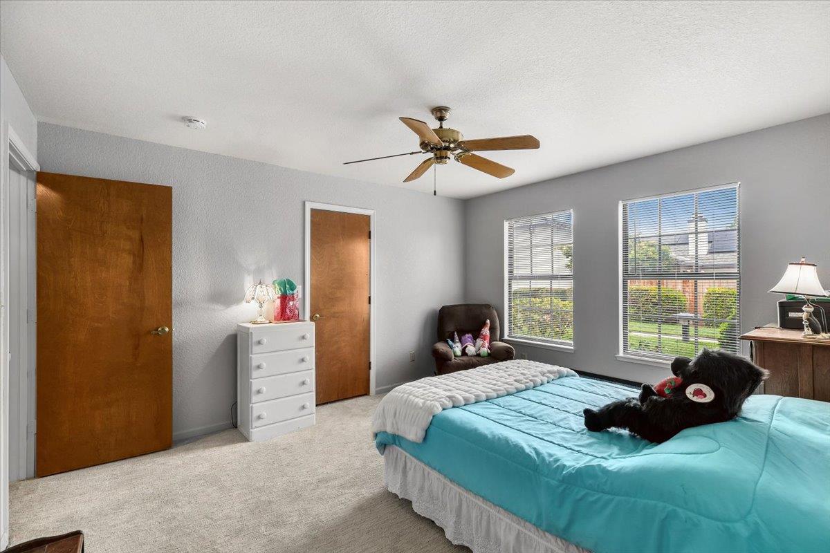 2136 Candy Cane Walk Manteca, CA 95336 - Photo 26 of 60 a bedroom with a bed next to a window and a chandelier