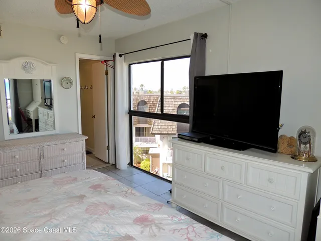 a room with two flat screen tv and a dresser