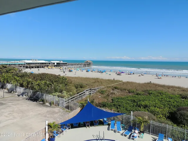 a view of a patio with table and chairs under an umbrella with wooden floor