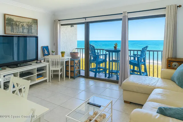 a work room with furniture a large window and a chandelier
