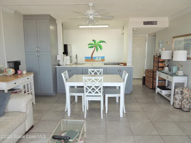 a dining room with furniture a chandelier a kitchen view and a fireplace