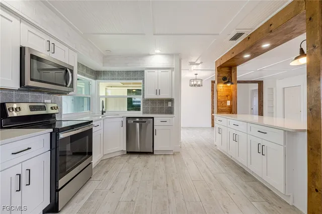 a kitchen with a refrigerator stove and white cabinets