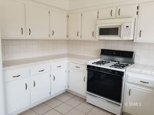 309 Petris Avenue Ridgecrest, CA 93555 - Photo 8 of 19 a kitchen with white cabinets and appliances