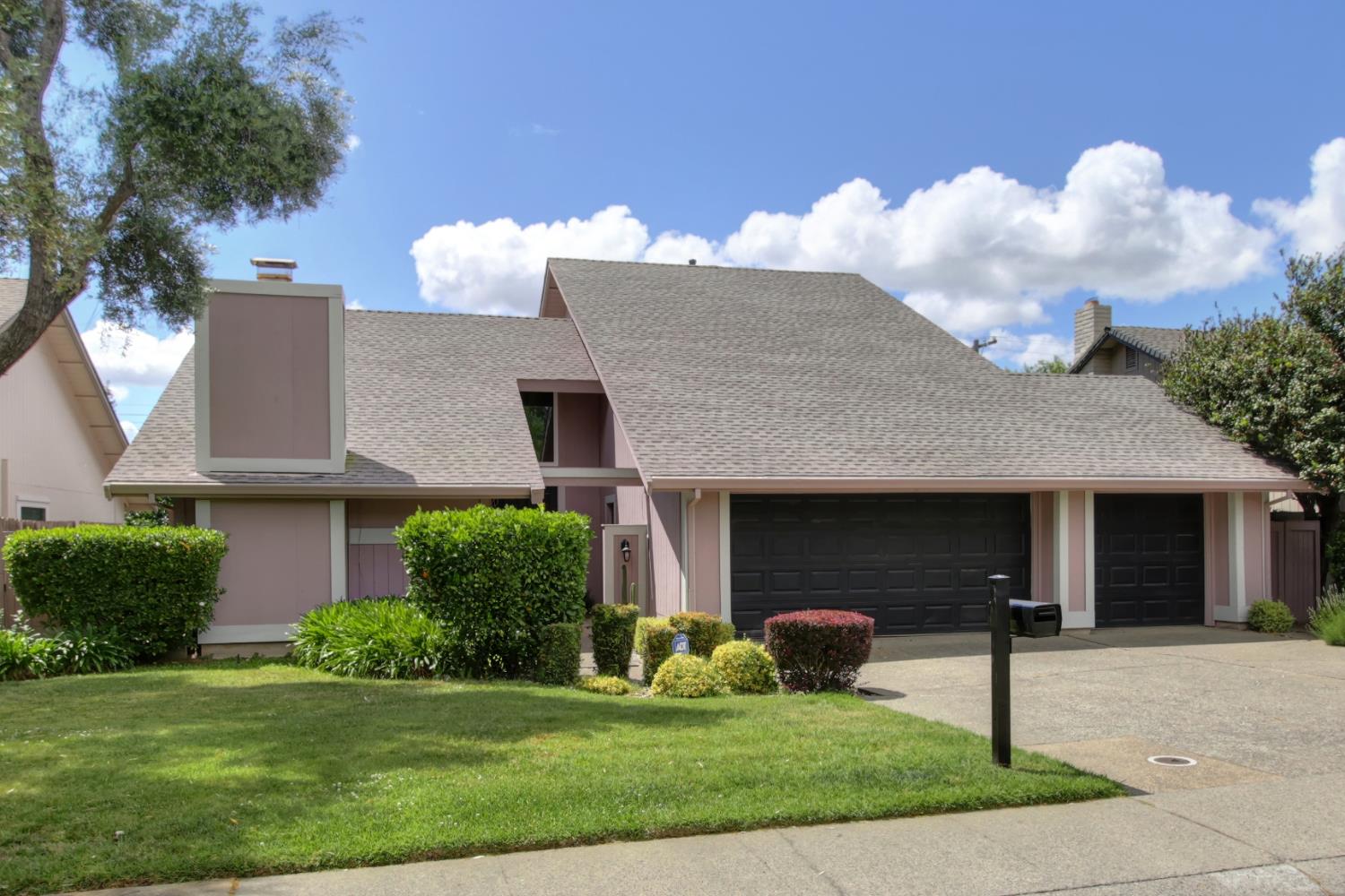 a front view of a house with a garden and plants