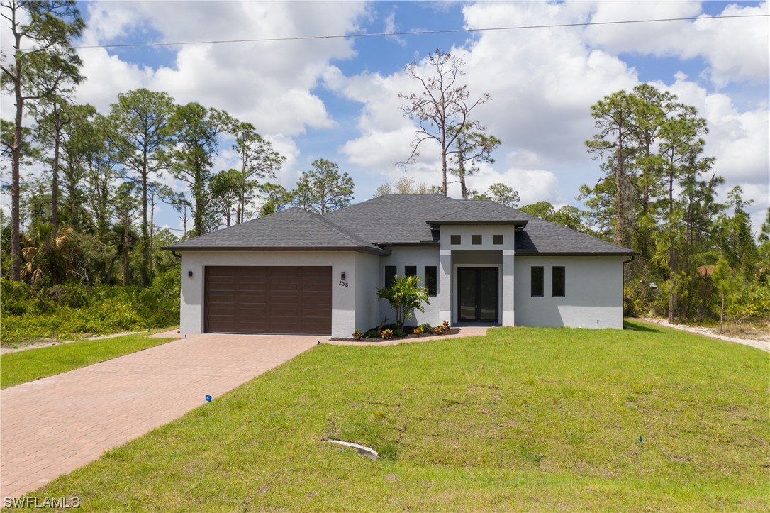 a front view of a house with yard and green space