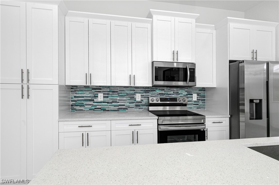 1119 Colonial Street East Lehigh Acres, FL 33974 - Photo 3 of 17 a kitchen with stainless steel appliances a stove a microwave and a refrigerator