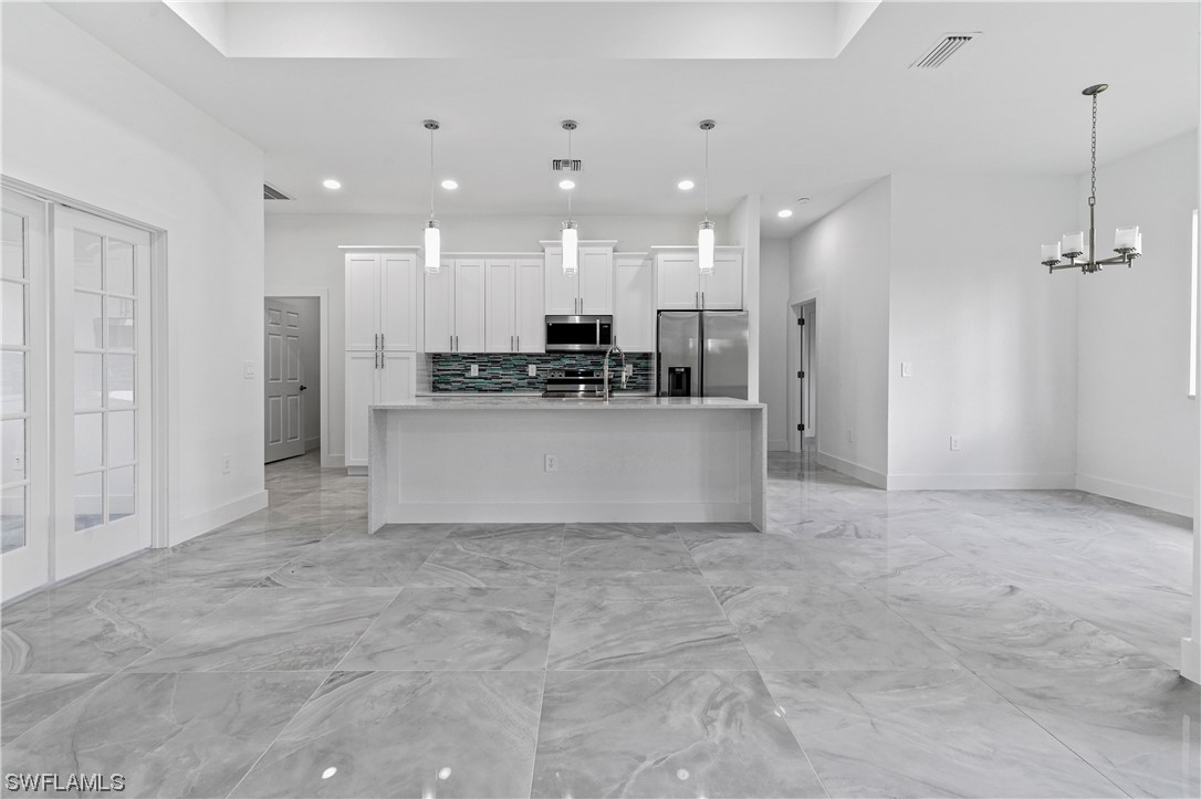 1119 Colonial Street East Lehigh Acres, FL 33974 - Photo 5 of 17 a view of a kitchen with stainless steel appliances kitchen island granite countertop a refrigerator and a stove top oven