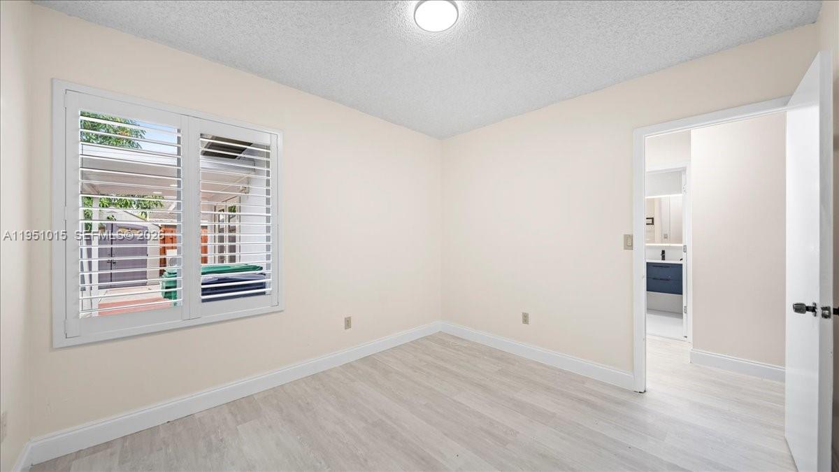 9798 Southwest 147th Place Miami, FL 33196 - Photo 11 of 17 a view of empty room with wooden floor and fan