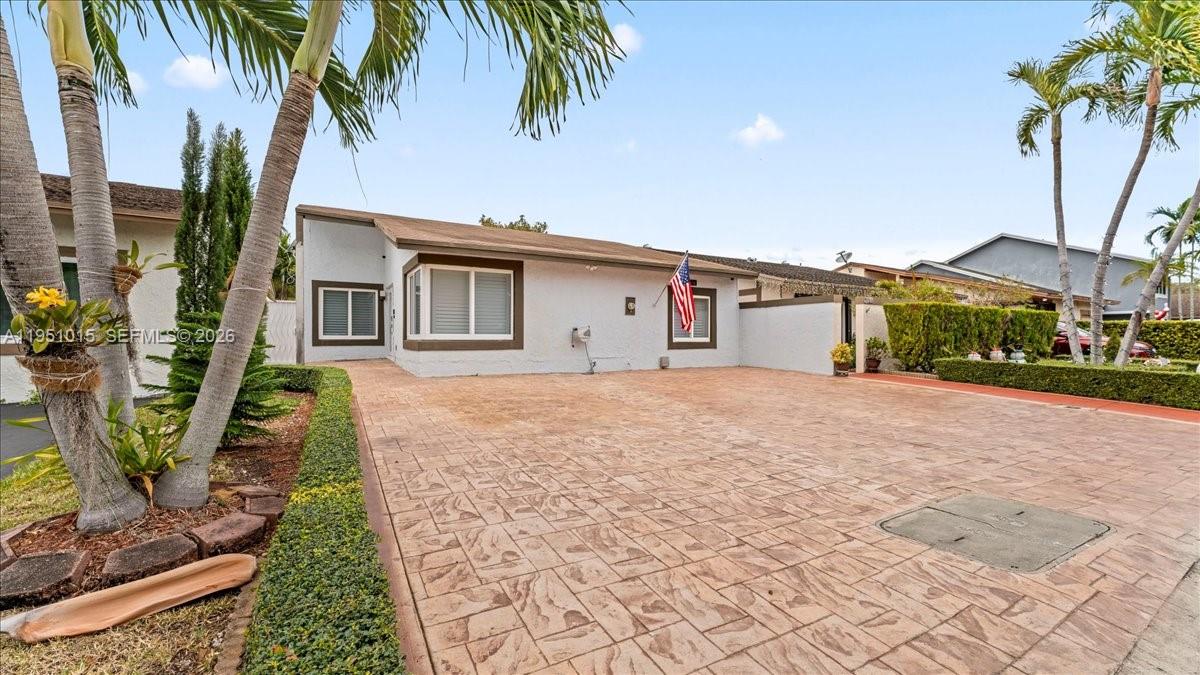 9798 Southwest 147th Place Miami, FL 33196 - Photo 2 of 17 a front view of a house with a yard and potted plants