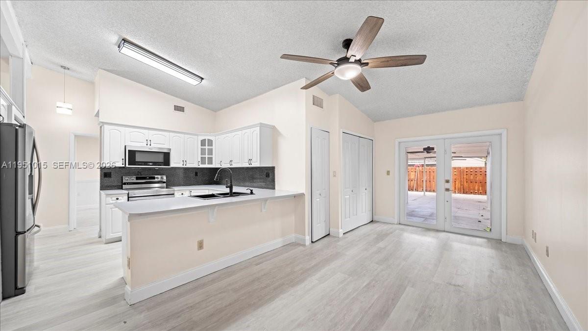 9798 Southwest 147th Place Miami, FL 33196 - Photo 5 of 17 a view of a kitchen with stainless steel appliances a refrigerator and a stove top oven