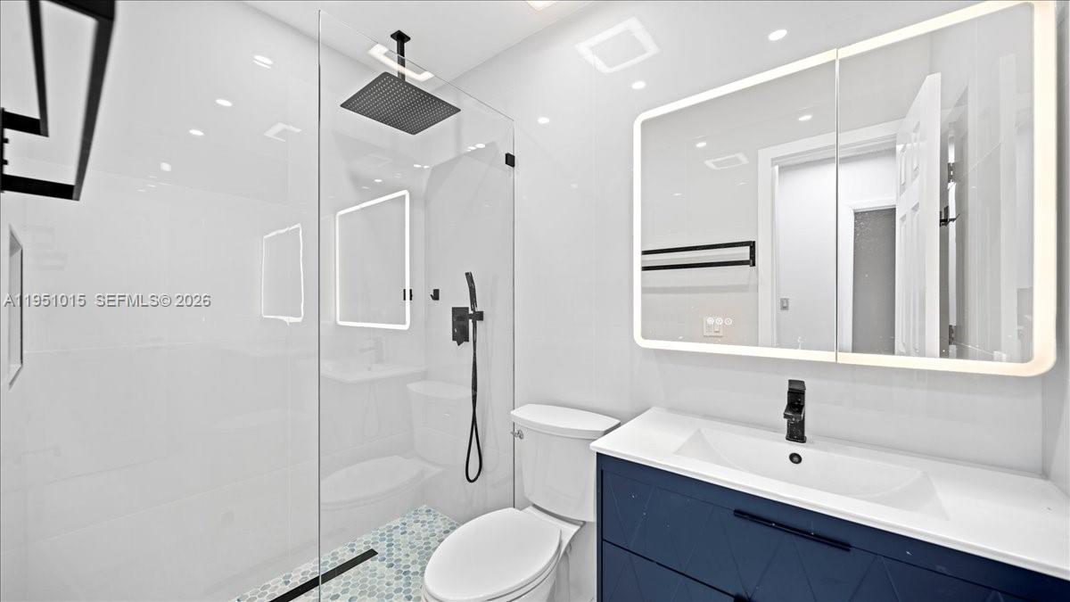 9798 Southwest 147th Place Miami, FL 33196 - Photo 10 of 17 a bathroom with a sink toilet a mirror and shower