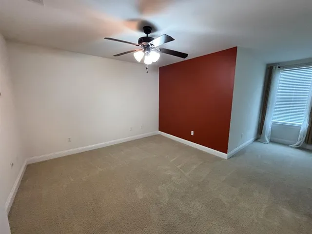 a view of a livingroom with a ceiling fan and window