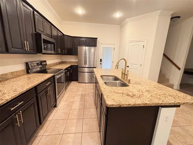 a kitchen with stainless steel appliances granite countertop a sink stove and refrigerator
