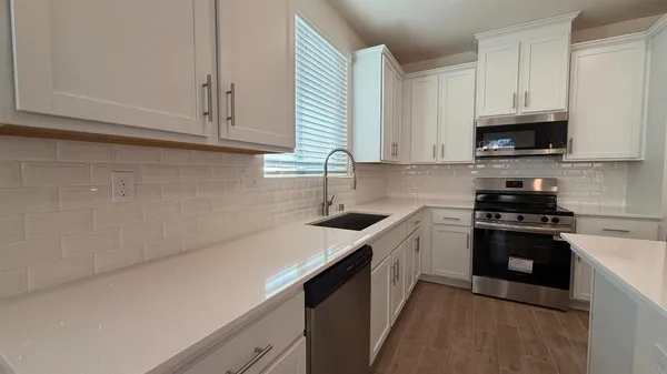 a kitchen with stainless steel appliances granite countertop a sink a stove a microwave and cabinets