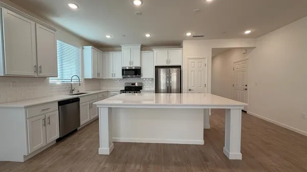 a kitchen with kitchen island a sink cabinets and wooden floor