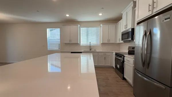 a kitchen with a refrigerator a sink and a stove top oven