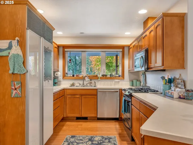 a kitchen with stainless steel appliances granite countertop a stove a sink and a refrigerator