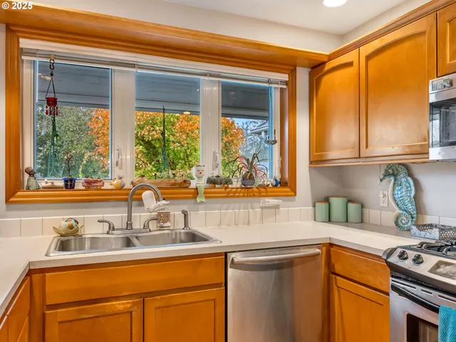 a kitchen with stainless steel appliances a sink a stove and a window