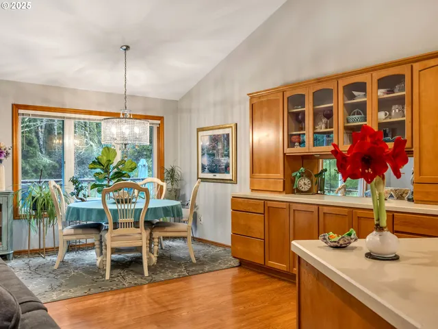 a dining room with furniture a floor to ceiling window and potted plants