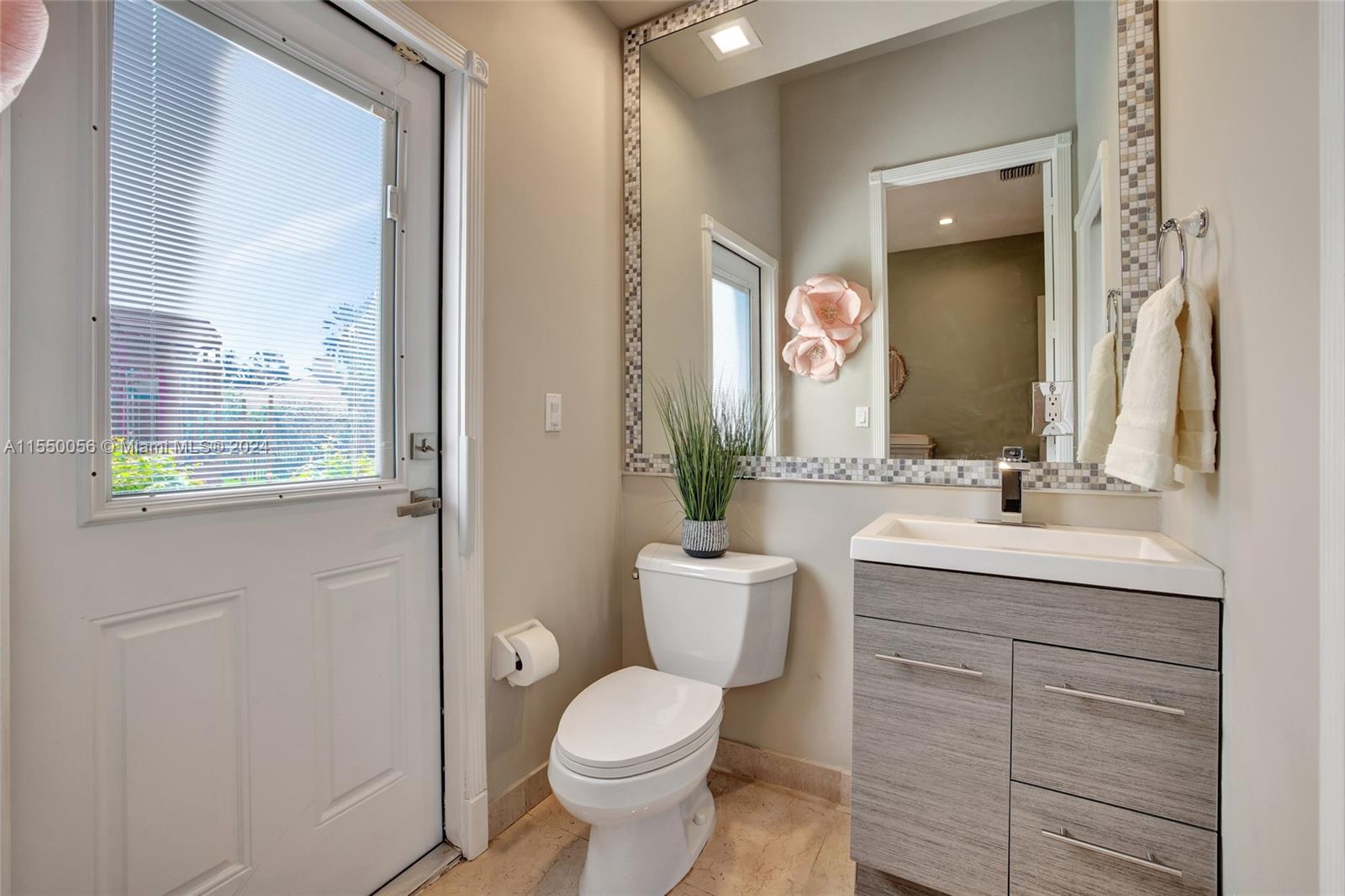 2725 Windmill Ranch Road Weston, FL 33331 - Photo 49 of 99 a bathroom with a granite countertop toilet a sink and a mirror