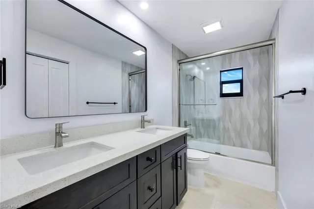 a view of a big room with windows and chandelier fan