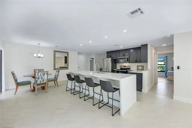 a kitchen with a sink and chairs